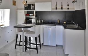 uma cozinha com armários brancos e um balcão preto em Le Gite Du Bastidon em La Tour-dʼAigues
