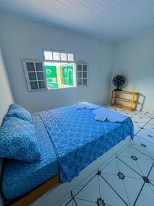 - une chambre avec un lit doté de draps bleus et une fenêtre dans l'établissement Pousada Sempre Viva Lençóis, à Lençóis