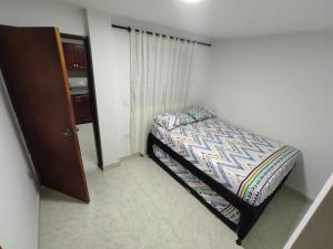 - une petite chambre avec un lit dans l'établissement Apartamento con jacuzzi En Bello - Cerca a Medellín, à Bello