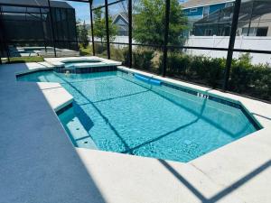 - une grande piscine d'eau bleue dans un bâtiment dans l'établissement Cozy 12BR Pool House/BBQ/Sleep 24/Near Disney, à Kissimmee