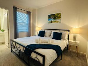 - une chambre avec un grand lit et 2 serviettes dans l'établissement Cozy 12BR Pool House/BBQ/Sleep 24/Near Disney, à Kissimmee