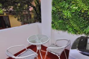 einen Tisch und Stühle auf einem Balkon mit Auto in der Unterkunft Casa Familiar, Amplia , acojedora y equipada in Cusco