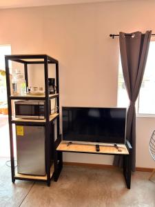 a tv stand in a living room with a microwave at Bugambilias 203 Oaxaca in Oaxaca City