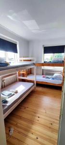 2 łóżka piętrowe w pokoju z drewnianą podłogą w obiekcie The Catch w mieście Køge