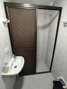 La salle de bains est pourvue d'une douche avec un lavabo et une porte de douche. dans l'établissement Apartamento con jacuzzi En Bello - Cerca a Medellín, à Bello