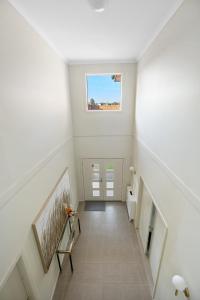 a white hallway with a staircase with a window at Spacious Villa 7BRM 5-bathroom House Point Cook Double Storey in Point Cook
