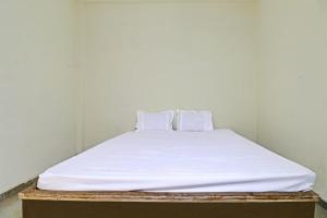 a bed with white sheets and pillows on it at SPOT ON 81062 Moonlight Hotel in Bhilai