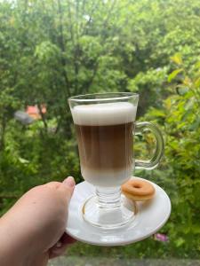 a person holding a cup of coffee and donuts on a plate at Termas Palguin in Pucón