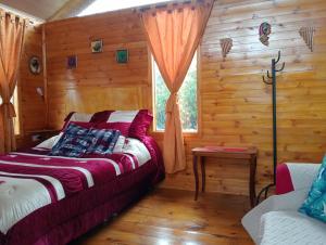 a bedroom with a bed in a log cabin at Cabaña Los Linos in Guasca