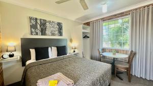 - une chambre avec un lit, une table et une fenêtre dans l'établissement Golden Grain Motor Inn, à Tamworth