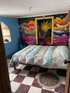 1 dormitorio con 1 cama con una pintura en la pared en aguaymanto, en Písac