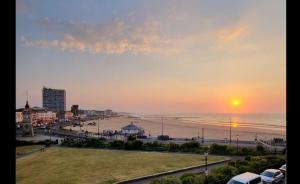 マーゲイトにあるSunset Point Apts - North Shore Suiteの海と夕日のビーチの景色