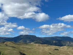 vista sulle montagne con cielo azzurro e nuvole di Pohokura Farmstay a Taihape