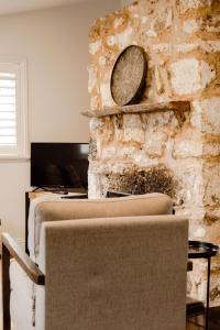 - une chambre avec 2 lits et un mur en pierre dans l'établissement The Dog House Cottage, à Port Fairy