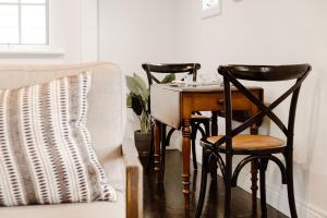 a table and two chairs next to a couch at The Dog House Cottage in Port Fairy