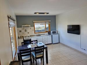 a kitchen with a table and chairs in a room at Les Eclaireurs Room in Ushuaia