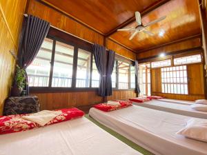 uma fila de camas num quarto com janelas em Duy Tuyen Ba Be Homestay Free BBQ em Bak Kan