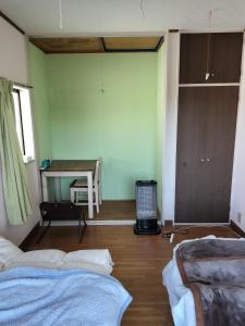 uma sala de estar com duas camas e uma mesa em 川っぺり　大出 em Kujukuri