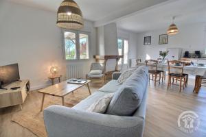 a living room with a couch and a table at Le rocher in Trélivan