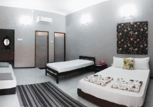 a hotel room with two beds and a rug at Al Sakinah Resort in Bentong +25 photos