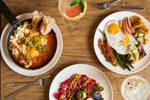 uma mesa com dois pratos de comida para o pequeno almoço em Selina Central Melbourne em Melbourne