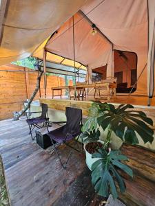 namiot z 2 krzesłami i rośliną na drewnianym tarasie w obiekcie Morning October w mieście Ban Kai Noi