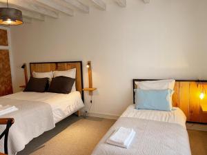 una camera da letto con due letti e un tavolo con una lampada di Gîte tout inclus à proximité de Beauval, 2 chambres, jardin, terrasse privée, animaux acceptés - FR-1-491-337 a Couffy