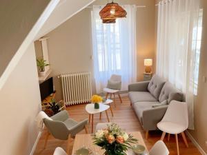 ein Wohnzimmer mit Sofa und Tisch in der Unterkunft Gîte tout confort pour 6-8 pers, cœur de village, parking privé, jardin clos, proche ZooParc de Beauval - FR-1-491-344 in Noyers-sur-Cher