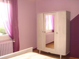 Schlafzimmer mit einem weißen Schrank und einem Spiegel in der Unterkunft Gîte Dhuizon, 4 pièces, 6 personnes - FR-1-491-348 in Dhuizon