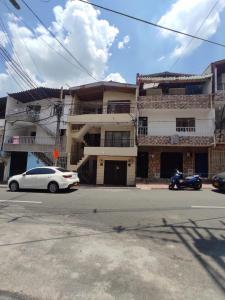 une voiture blanche garée devant un bâtiment dans l'établissement Apartamento con jacuzzi En Bello - Cerca a Medellín, à Bello