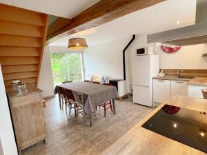 eine Küche und ein Esszimmer mit einem Tisch und einem Kühlschrank in der Unterkunft Gîte tout confort près du Zoo de Beauval avec jardin, terrasses et équipements modernes - FR-1-491-356 in Noyers-sur-Cher