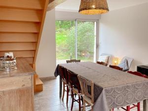 ein Esszimmer mit Tisch und Stühlen und einem Fenster in der Unterkunft Gîte tout confort près du Zoo de Beauval avec jardin, terrasses et équipements modernes - FR-1-491-356 in Noyers-sur-Cher + 20 Fotos