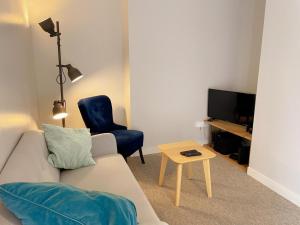 ein Wohnzimmer mit einer Couch, einem Sessel und einem Tisch in der Unterkunft Gîte tout confort près du Zoo de Beauval avec jardin, terrasses et équipements modernes - FR-1-491-356 in Noyers-sur-Cher