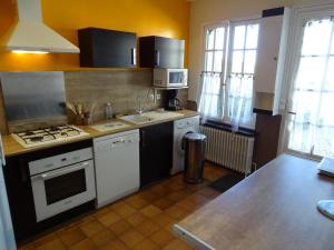 a kitchen with a sink and a stove top oven at Longère paisible avec jardin, près châteaux de la Loire et Zoo de Beauval - FR-1-491-339 in Pouillé