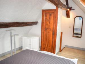 a bedroom with a bed and a wooden door at Gîte chaleureux près des Châteaux de la Loire, avec terrasse, équipements de loisirs et pêche - FR-1-491-357 in Cour-Cheverny