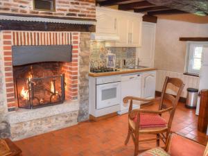 クル・シュヴェルニにあるCharmant gîte pour 5 pers. près des Châteaux avec animaux admis - FR-1-491-345のキッチン(レンガ造りの暖炉、テーブル、椅子付)