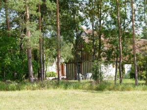 a house in the middle of a field with trees at Gîte chaleureux près des Châteaux de la Loire, avec terrasse, équipements de loisirs et pêche - FR-1-491-357 in Cour-Cheverny