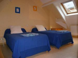 クル・シュヴェルニにあるGîte familial au cœur des Châteaux de la Loire, animaux acceptés - FR-1-491-360のブルーシーツ付きの客室内のベッド2台