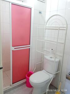 a bathroom with a toilet and a red door at Apartamento equipado frente de la bahía de pampatar in Pampatar
