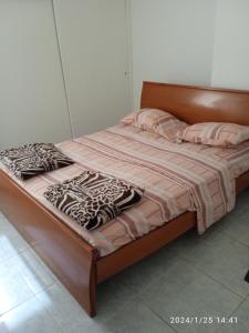 a bed with pink and white sheets and pillows at Apartamento equipado frente de la bahía de pampatar in Pampatar