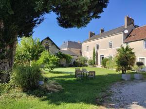 un parco con una panchina davanti a un edificio di Gîte 18ème avec jardin, jeux, et ateliers cuisine près de l'Abbaye de Pontlevoy. - FR-1-491-349 a Pontlevoy
