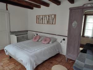 ein Schlafzimmer mit einem Bett mit rosa Kissen darauf in der Unterkunft Gîte Pontlevoy, 4 pièces, 4 personnes - FR-1-491-349 in Pontlevoy
