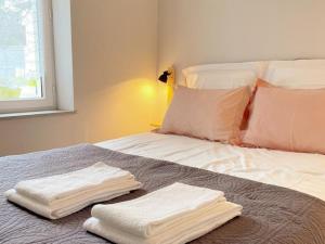 un letto con due asciugamani bianchi seduti sopra di Gîte confort pour 2 avec jardin privatif près des châteaux et du Zooparc de Beauval - FR-1-491-368 a Couffy