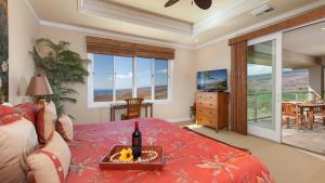 a bedroom with a bed with a bottle of wine on it at Beautiful Ocean Villa Beautiful Mauna Kea Home with Sunsets and Ocean Views in Hapuna Beach