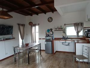 a kitchen with a table and a table and chairs at Casa 2 pisos Para 5 personas toda equipada in Colonia del Sacramento