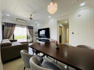 莎阿南的住宿－Orak Villa Homestay at Suria Residence，客厅配有桌椅和电视。