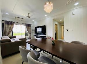 a living room with a table and chairs and a television at Orak Villa Homestay at Suria Residence in Shah Alam