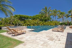 a swimming pool with three chairs and a swimming pool at OCEAN PALSM VILLA Refined 3BR Waiulaula Home with Stunning Ocean Views in Hapuna Beach