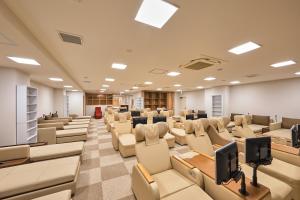 una sala de conferencias vacía con sillas y escritorios en Sauna & Capsule Hotel Rumor Plaza en Kioto