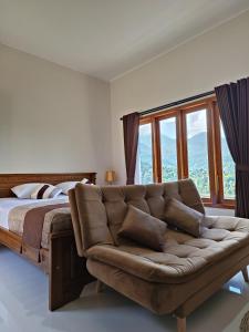 una camera con divano e letto con finestre di Made Oka Homestay and Warung a Munduk